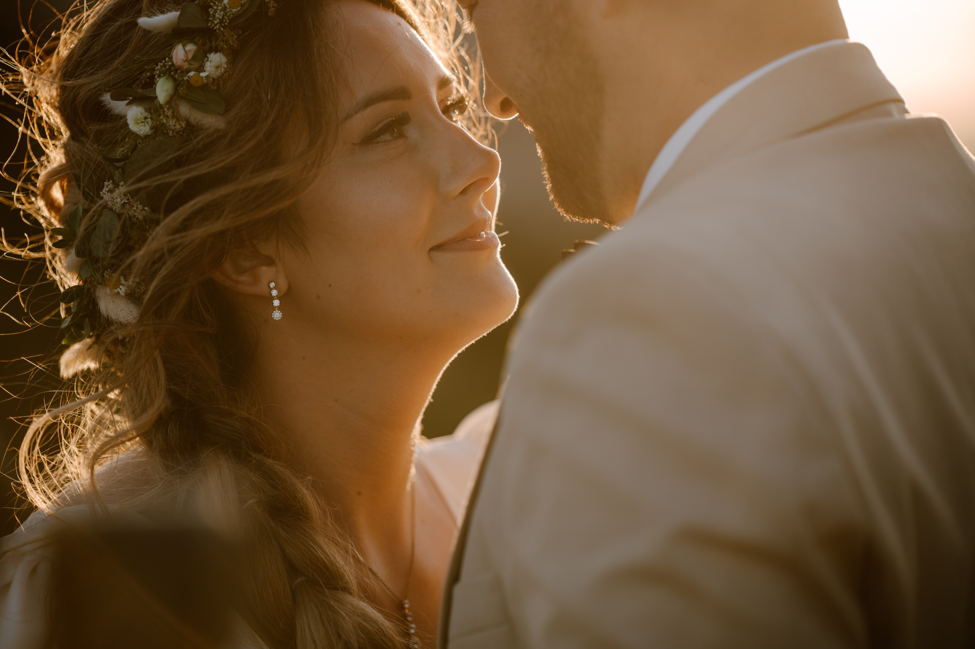 Panna młoda patrząca na męża podczas romantycznego zdjęcia w ciepłym świetle